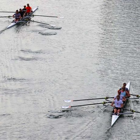 Two teams of kayak rowers going down a river